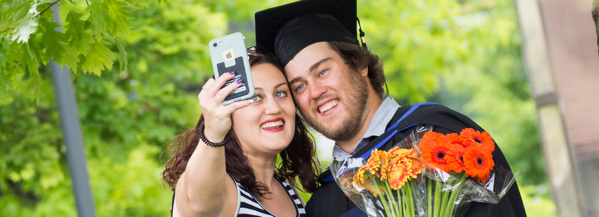A graduate and woman taking a selfie